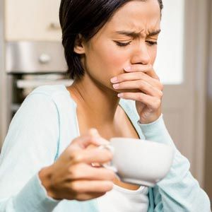 woman holding her mouth in pain
